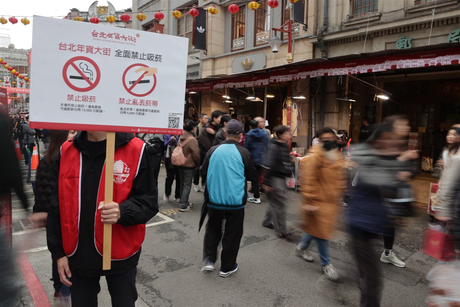 台北年貨大街日前登場，今年擴大整個街區禁菸，環保局、衛生局巡查，勸導吸菸民眾前往限定吸菸區。記者許正宏／攝影 