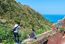 藍天、綠山以及紅磚厝，吸引許多遊客駐足拍攝。