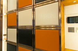 牆壁上的收納櫃揚棄傳統古板的原木色拘謹的設計，而是採用咖啡、黑與橘色的穿插設計，在內斂中透露出熱情。