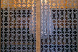 兼具透氣與造型的次主臥衣櫥拉門。拉門上以金屬簍空的方式，呈現出傳統窗棱的幾何美麗花紋。