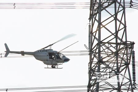 年終大掃除曾經協助拍攝《看見台灣》的直升機，為了清洗電塔絕緣礙子，幾乎緊貼著高壓電塔與電線盤旋，違反避開電塔、電線的飛行常規，考驗飛行員技術。（簡榮輝攝） 