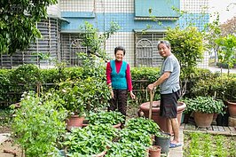 一樓的住戶門前都有約20坪左右的私人綠地空間。一對已經退休含飴弄孫的老夫妻，正整理花圃迎接新春到來。