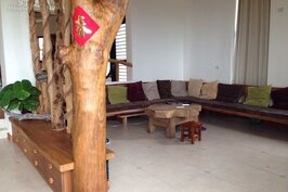 客廳有著一體成型的木頭沙發，並以原木作為區隔。
