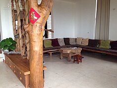 客廳有著一體成型的木頭沙發，並以原木作為區隔。