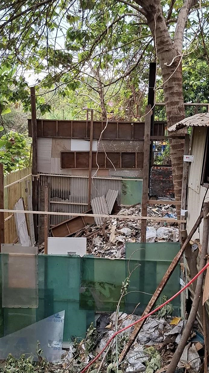 大里吉善路近旱溪邊坡驚見新搭建塑膠棧板平台，下方遭傾倒大量廢棄物，旁邊工寮也倒滿破碎磁磚，還有另1間往溪底排放糞便水的簡易廁所。圖／張芬郁提供
