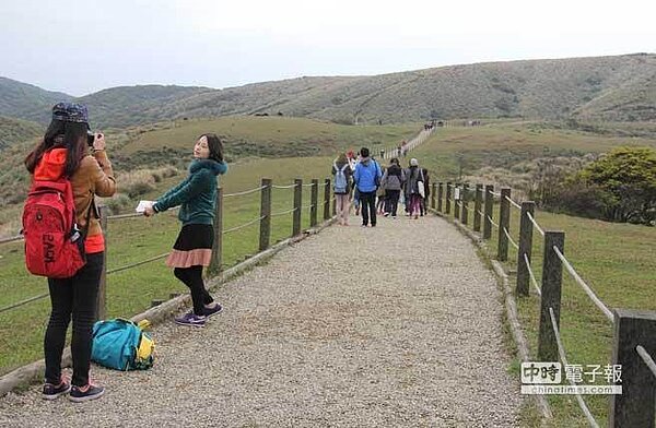圖為在陽明山國家公園拍照的自由行陸客。(記者李鋅銅攝)