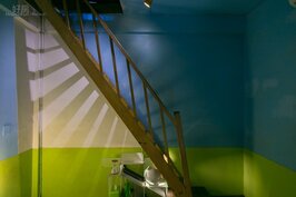 通往三樓的木頭樓梯在刻意照印的光線下成為後現代藝術品。